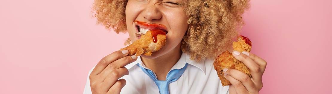 Cheerful Curly Haired Woman Eats Delicious Meal Fast Food Smeared With Ketchup Keeps Unhealthy Nutrition Has Binge Eating Habit Wears White Shirt Blue Tie Isolated Pink Background Copy Copy